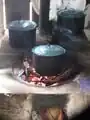 Fig 2d: Improved cook stove in use without comalW so the dish receives direct heat. In the morning this produces little smoke, but by the afternoon the smoke no longer escapes out the chimney. It rises through the comal opening into the house.