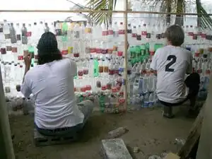 Fig 8: Slowly rolling chicken wire up the wall as bottles are placed inside.