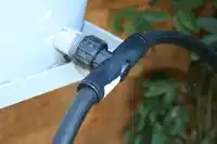 Figure 3: The T-fitting located at the storage bucket outlet splits the main water line to allow watering of multiple beds.[1]