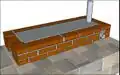 The chimney is installed through a prefabricated hole in the back of the plancha. Sometimes the chimney is not inserted into this hole, and in these cases the plancha is covered and sealed with bricks and mortar.