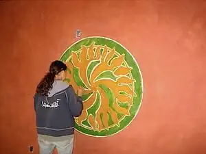 Students at Cal Poly Humboldt use egg paint to create this logo for the interior wall of the Campus Center for Appropriate Technology.[12]